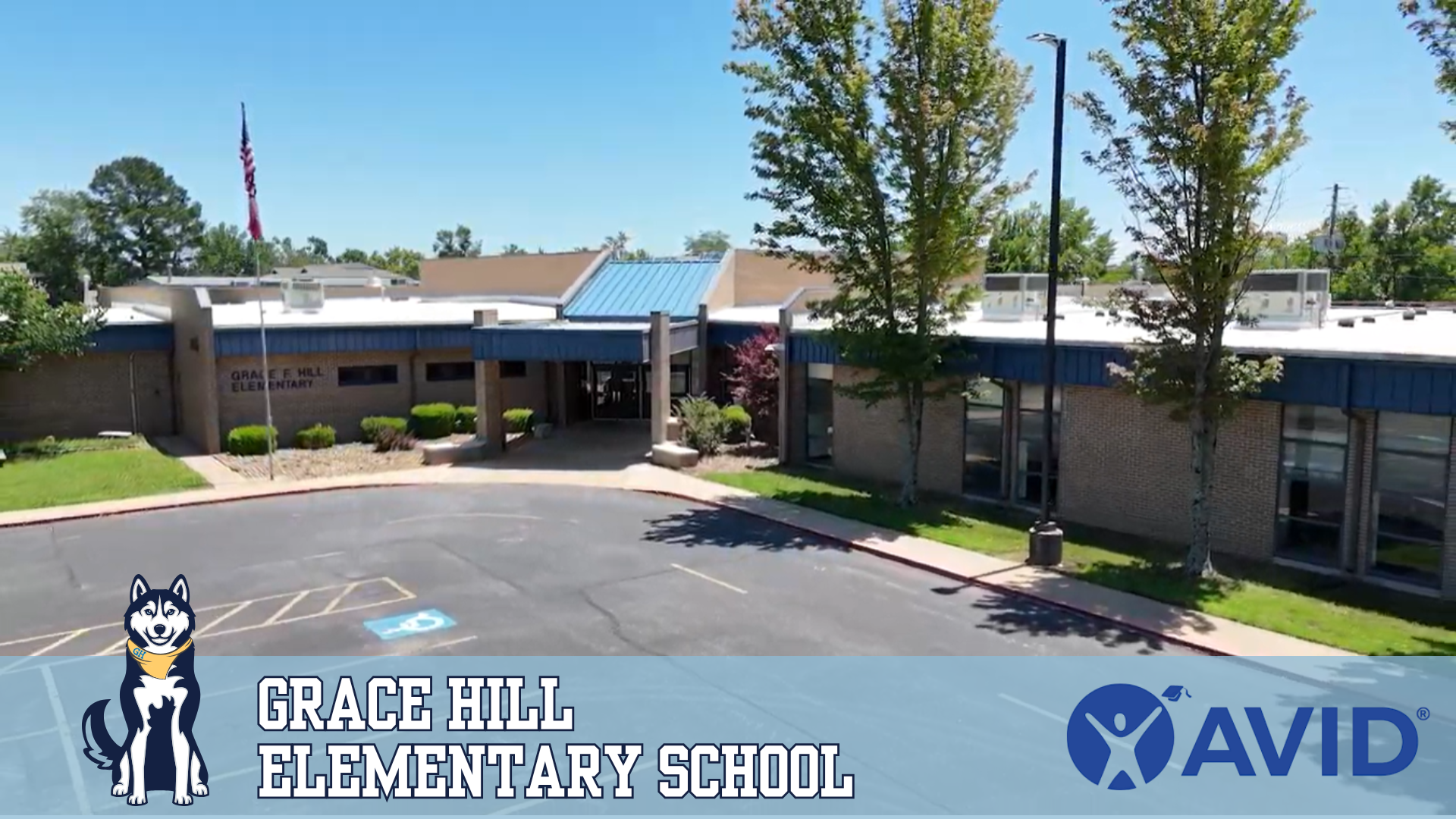 Exterior view of Grace Hill Elementary with its husky mascot, name and the AVID logo.